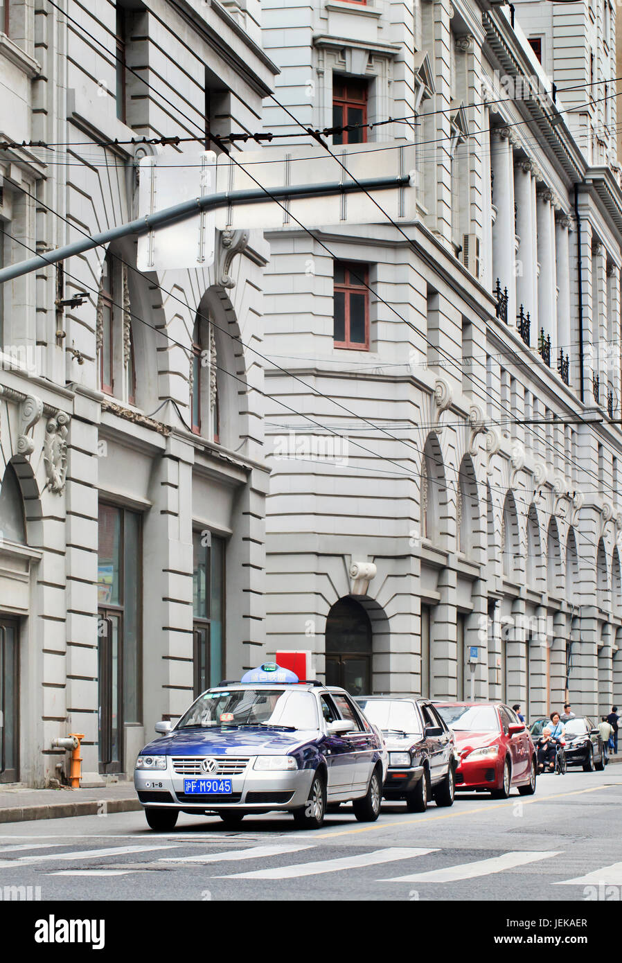 SHANGHAI – 5 JUIN 2014. Voitures en attente de vert dans une rue avec des bâtiments coloniaux. La ville possède l’une des plus grandes collections art déco au monde. Banque D'Images