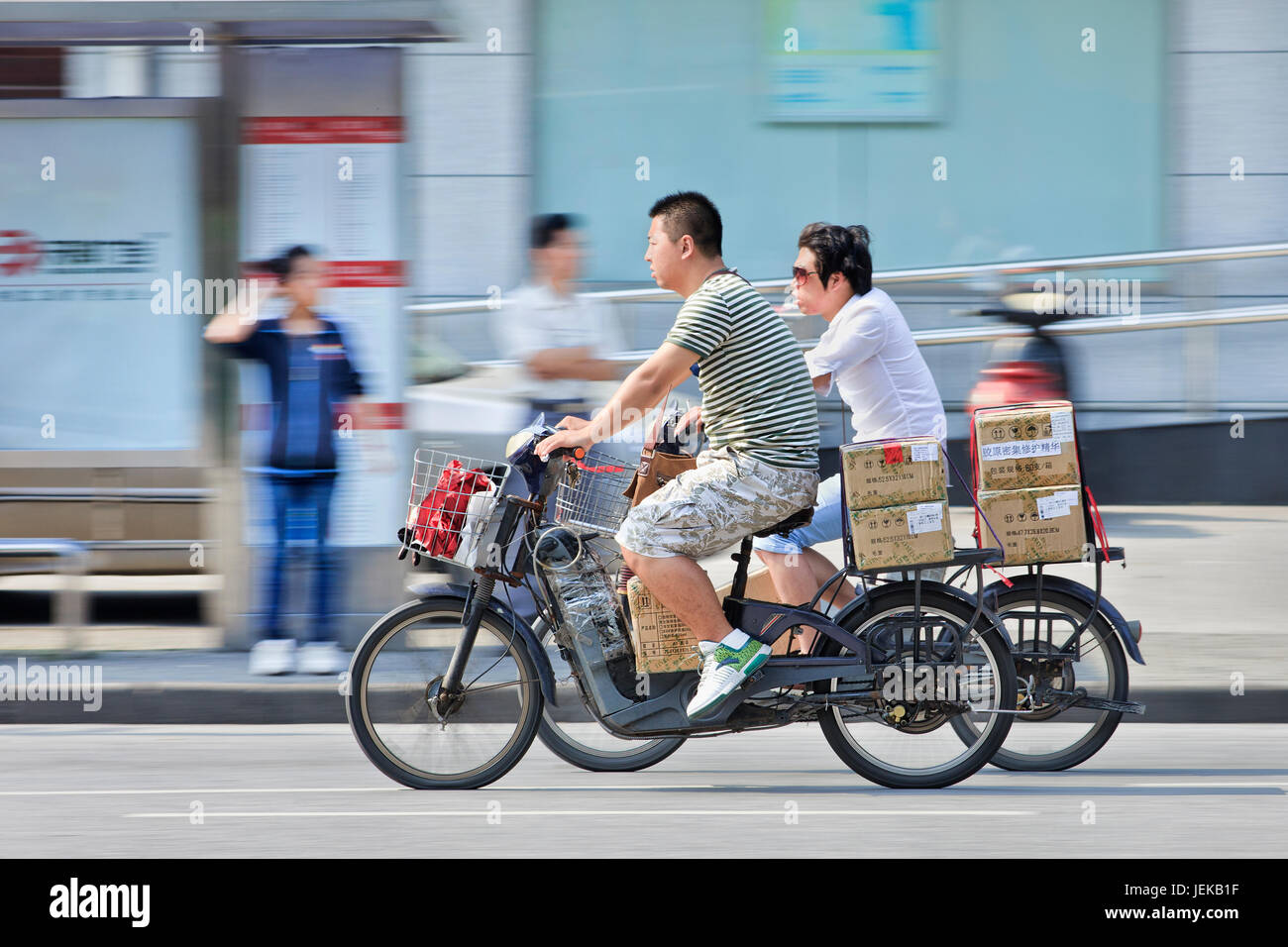La livraison de colis sur e-bikes. Au moins 120 millions d'e-bikes sont sur les routes chinoises, et les ventes sont de plus en plus seulement grâce à une combinaison de la chute des prix. Banque D'Images