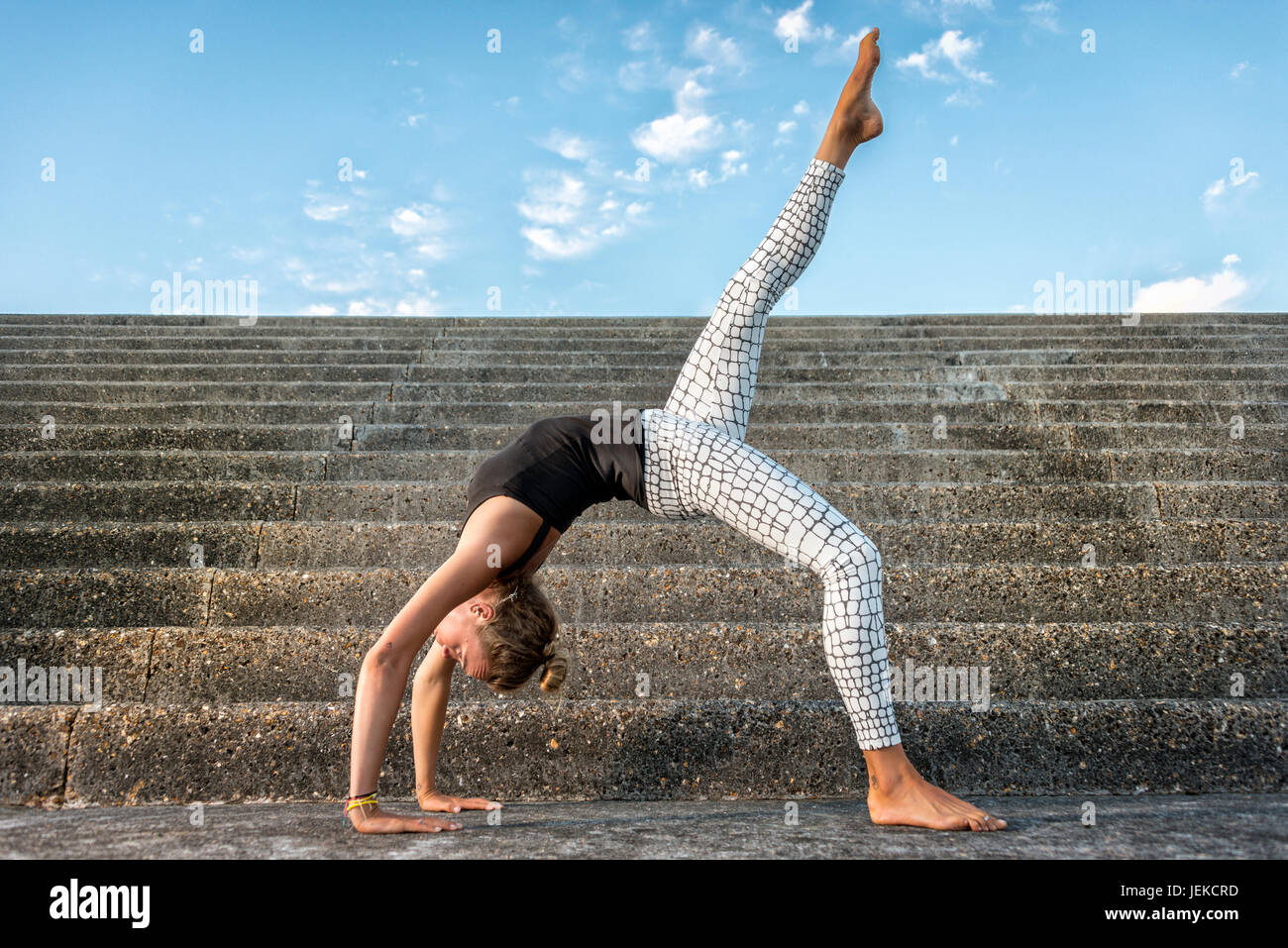 Woman practicing yoga sur des mesures concrètes à outsde Banque D'Images