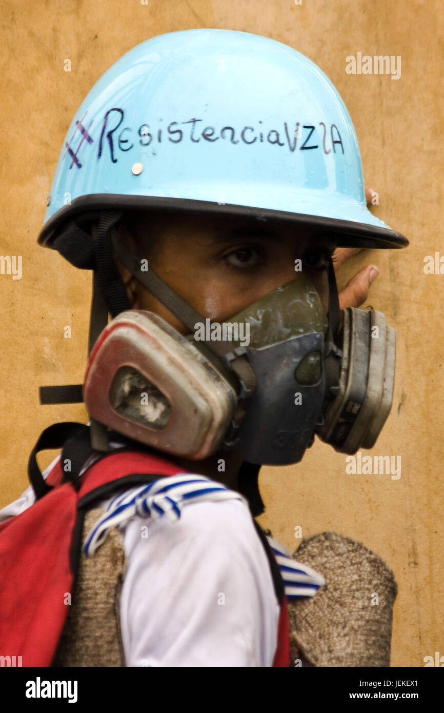 Un jeune manifestant à l'aide d'un casque. Banque D'Images