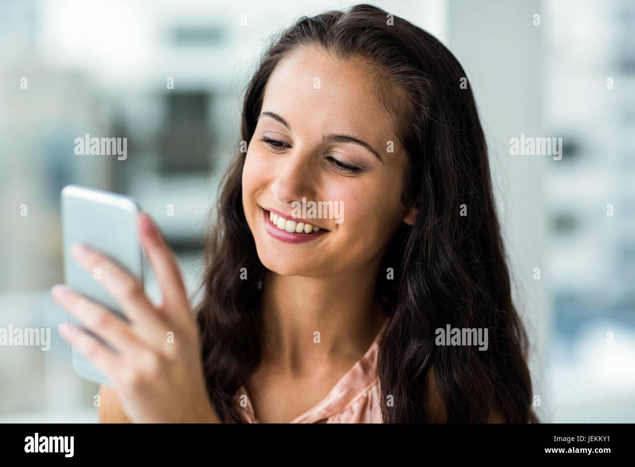 Smiling woman using smartphone Banque D'Images