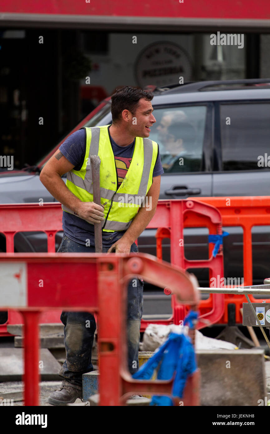 Un ouvrier de la Société d'ingénierie civile "Terre & Building Services pose des dalles en béton" le long de la zone Nethergate à Dundee, Royaume-Uni Banque D'Images