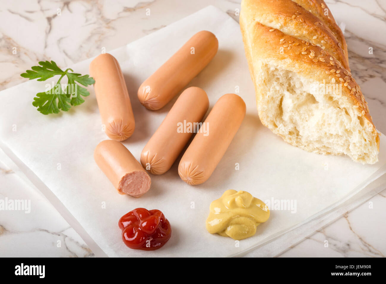 Saucisses (Frankfurter) sur table rustique avec du pain, de la moutarde et du ketchup Banque D'Images