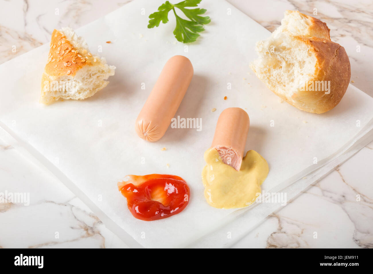 La consommation de saucisses (Frankfurter) sur papier avec du pain, de la moutarde et du ketchup Banque D'Images