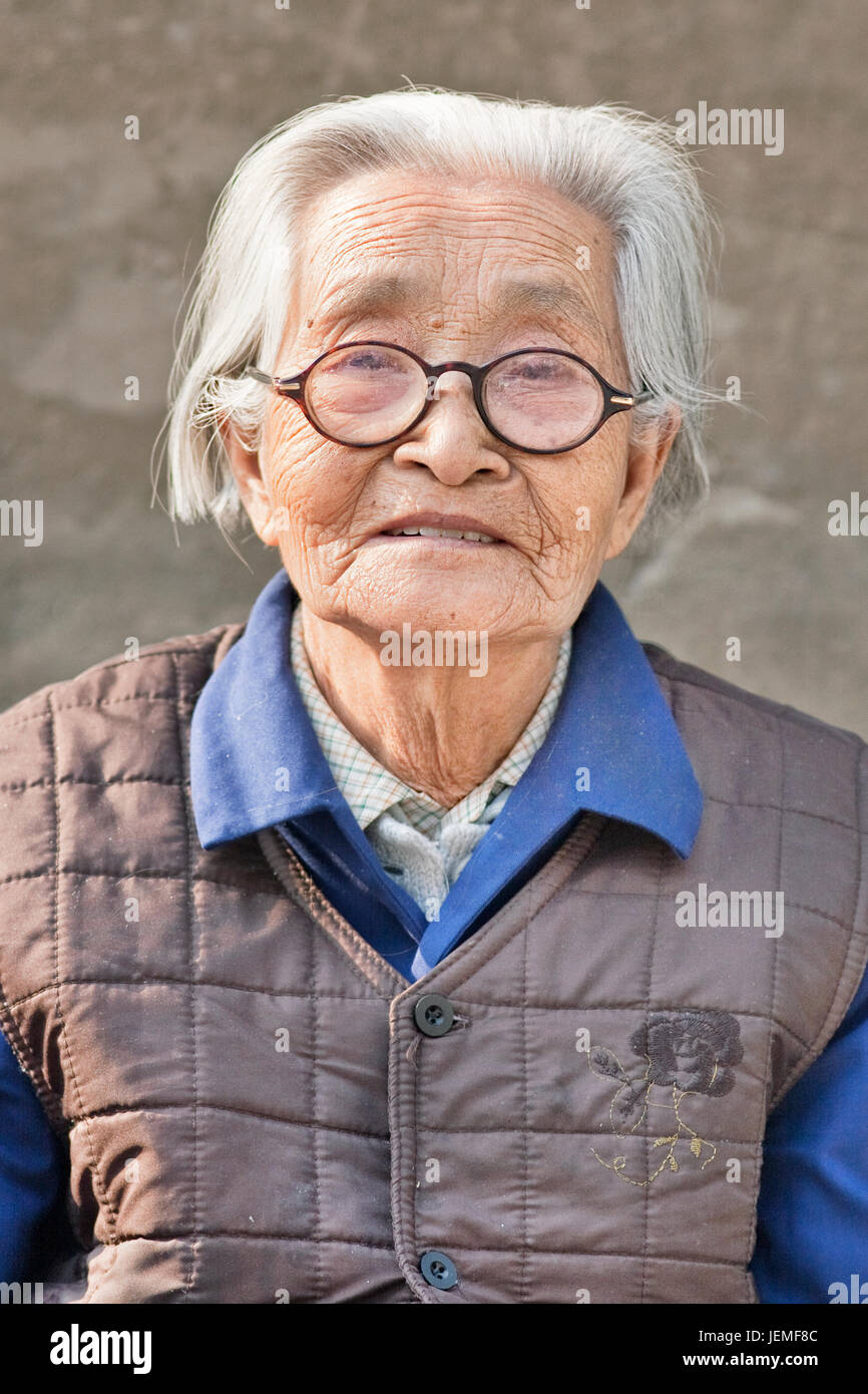 Vieille femme chinoise avec des lunettes. Les personnes âgées, la Chine top 300 millions en 2025. En 2042, plus de 30  % de la population âgés de plus de 60 ans. Banque D'Images