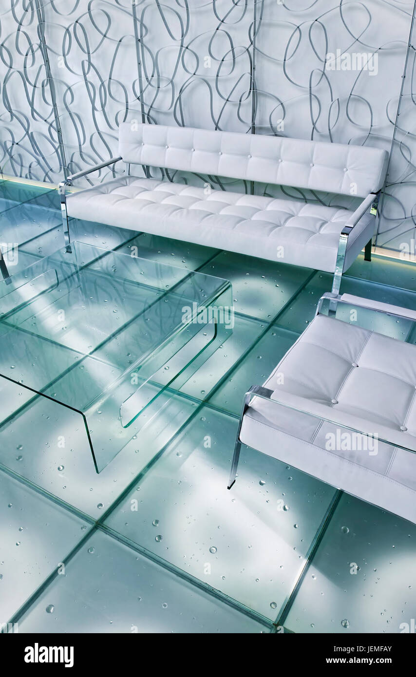 Design élégant intérieur avec une mousse blanche divan et fauteuil, table  basse en verre et un sol en carreaux de verre carré Photo Stock - Alamy