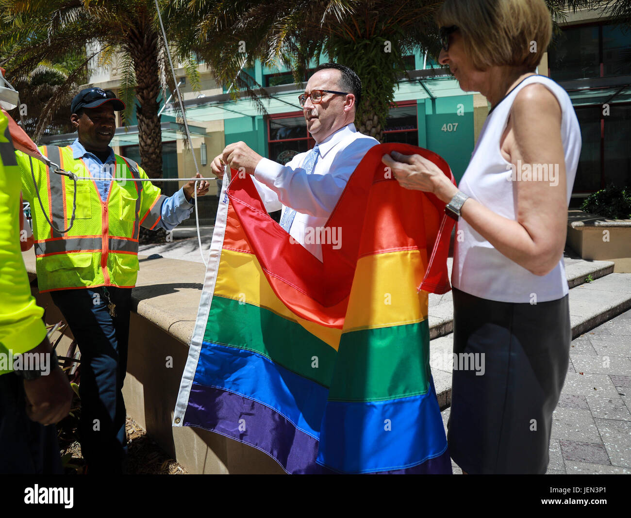 En Floride, aux États-Unis. 26 Juin, 2017. West Palm Beach Maire Jeri Muoio (à droite) et Stephen Dimanche (centre) se préparent à lever le drapeau arc-en-ciel à l'Hôtel de ville dans la région de West Palm Beach Lundi, 26 juin 2017. Le drapeau arc-en-ciel, la bannière de la fierté, le mouvement va voler à l'Hôtel de Ville durant les derniers jours de juin pour promouvoir l'égalité, l'unité et la diversité. Le dimanche est un pionnier dans le domaine de l'égalité du mariage et dans la lutte pour la recherche sur le sida et la sensibilisation. Le Mois de la fierté LGBT est célébré en juin. Hier marquait l'anniversaire de la date à laquelle Gilbert Baker d'abord soulevé le drapeau arc-en-ciel (25 juin 1978) ; aujourd'hui, c'est le Banque D'Images