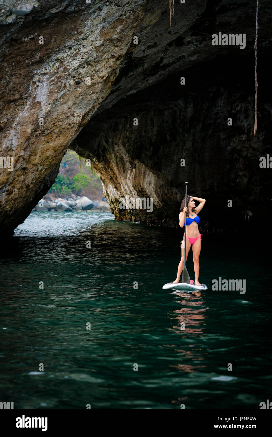 Man paddleboarding, explorer des grottes et des rochers en mer, Los Arcos National Marine Park, côte Pacifique du Mexique Banque D'Images
