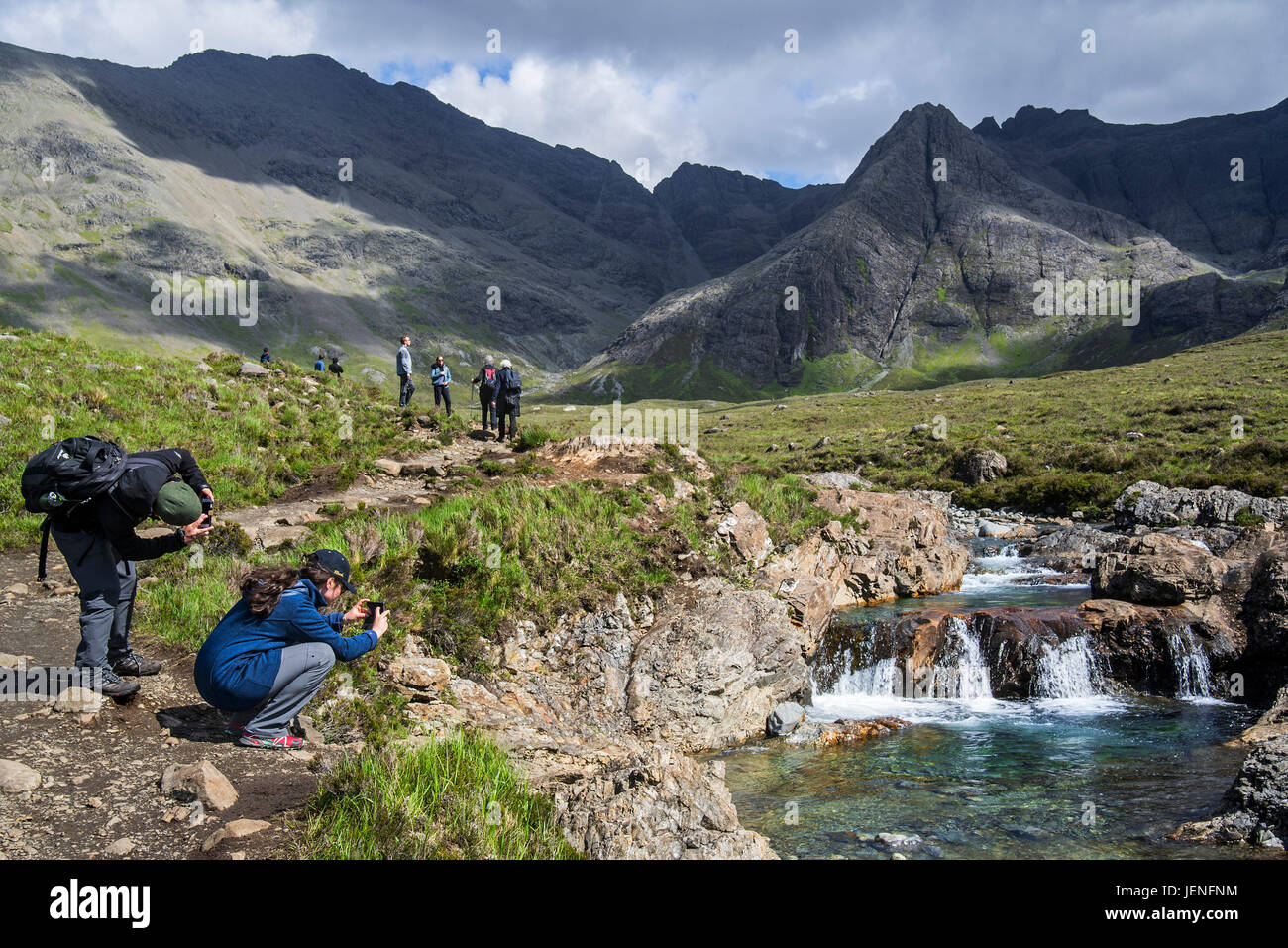 Les marcheurs à prendre des photos de la Fée des piscines, succession de cascades à Glen cassantes sur l'île de Skye, Highlands, Scotland, UK Banque D'Images