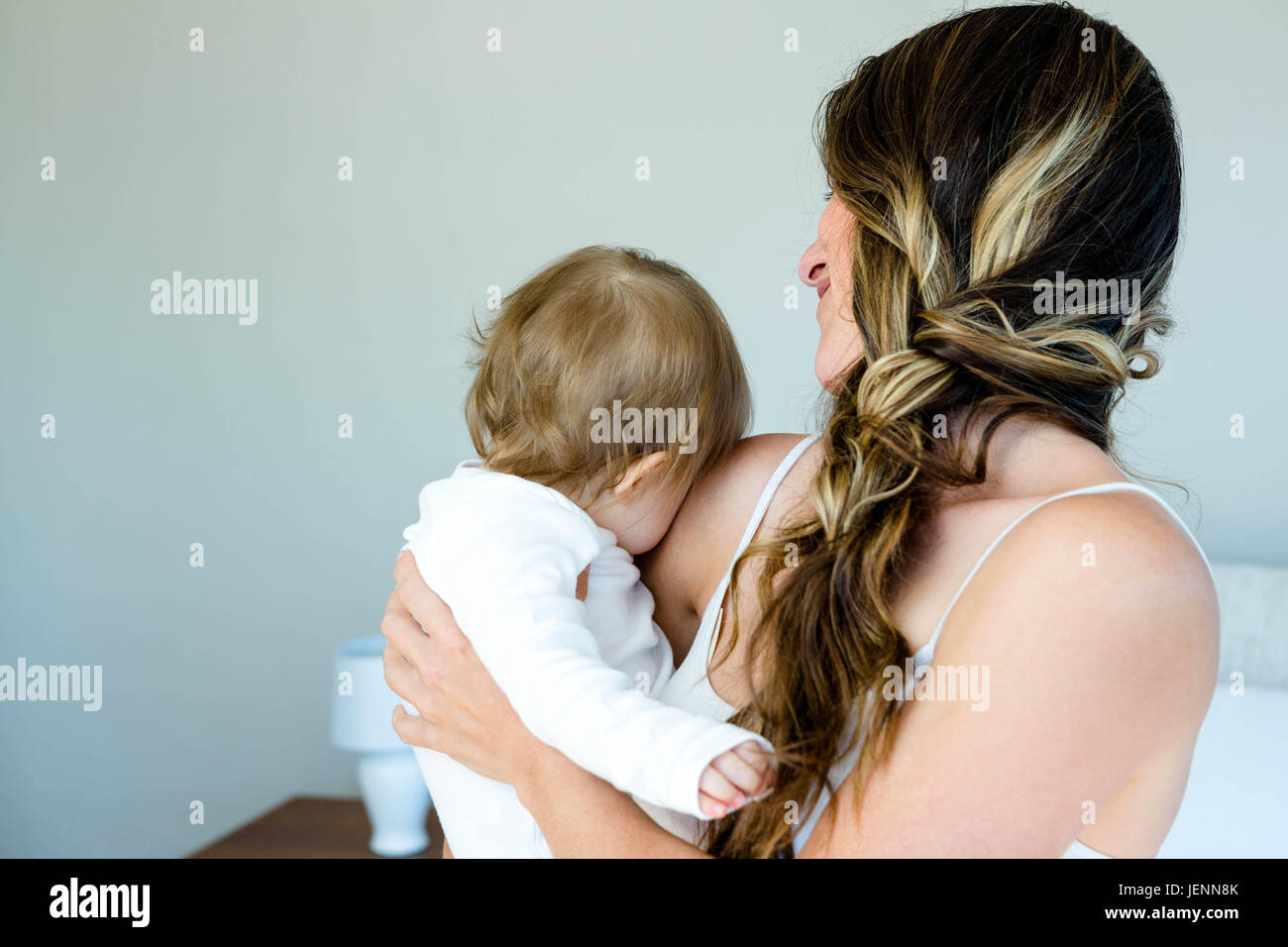Smiling brunette woman holding a baby Banque D'Images