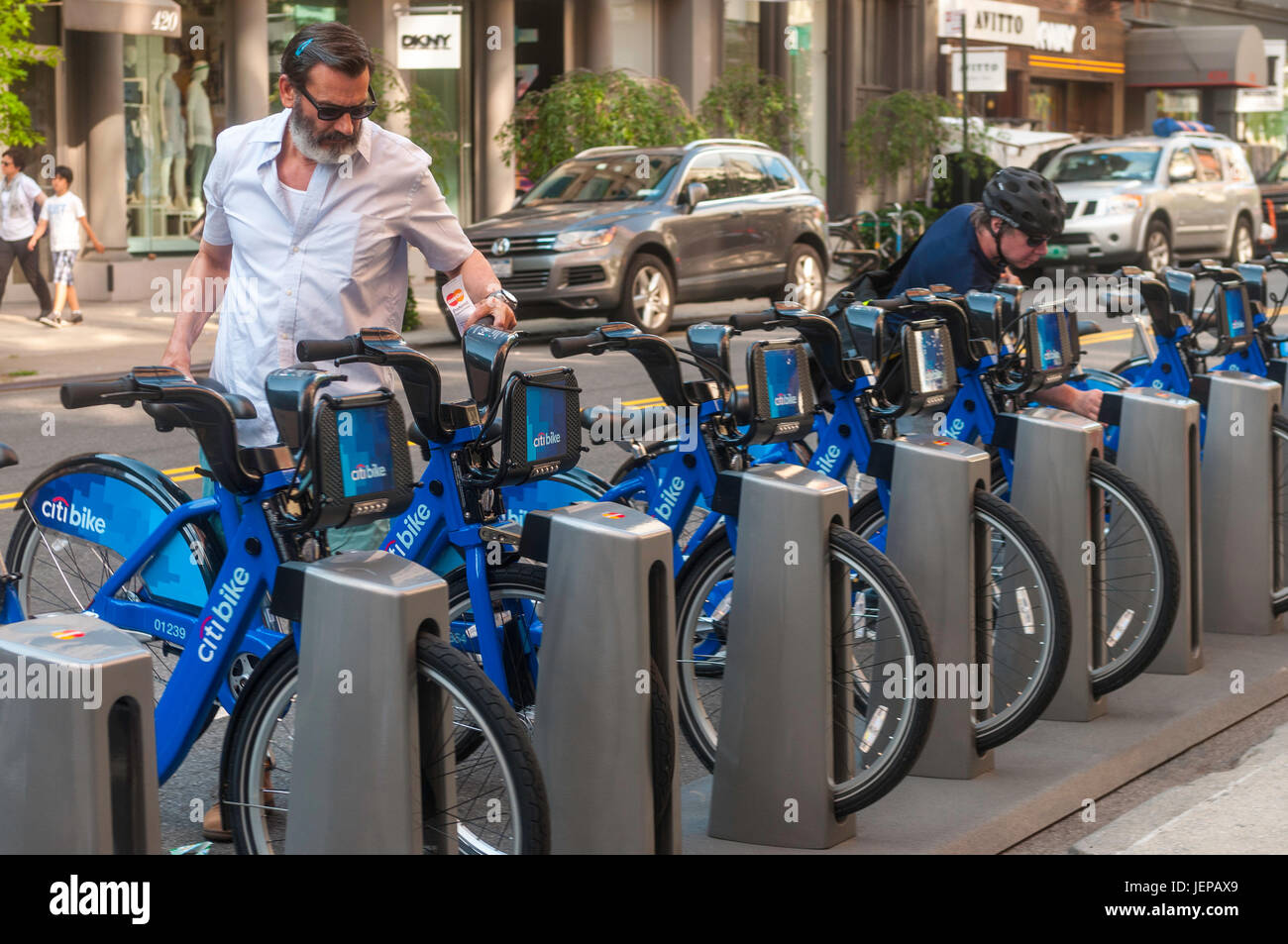 New York, USA Les cyclistes choisissez et de retour des vélos à un CitiBike station dans le quartier Soho de Manhattan. Banque D'Images
