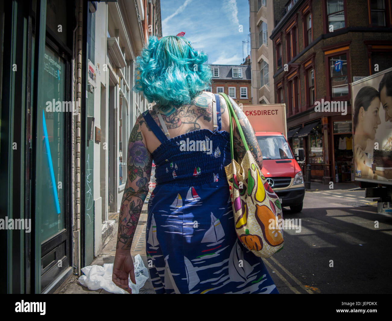 Une dame aux cheveux bleus et beaucoup de tatouages à Soho, Londres Banque D'Images