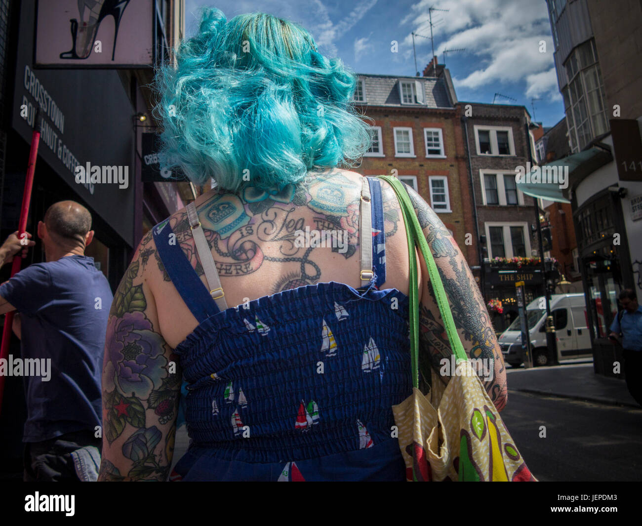 Une dame aux cheveux bleus et beaucoup de tatouages à Soho, Londres Banque D'Images