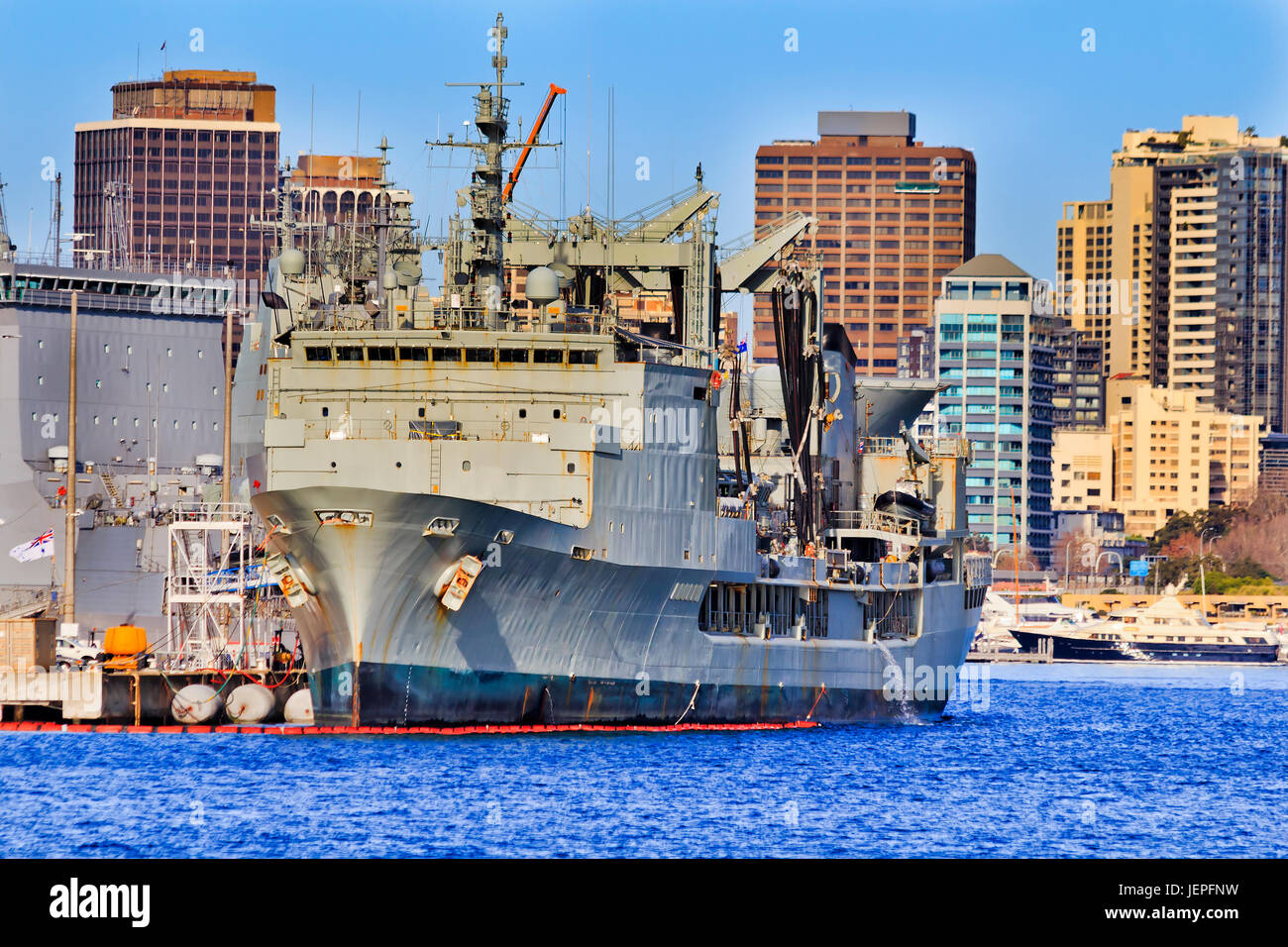 L'avant du navire australien de Sa Majesté à la base de la marine militaire à Sydney Cove sur une journée ensoleillée à l'encontre des tours d'habitation Maisons. Banque D'Images