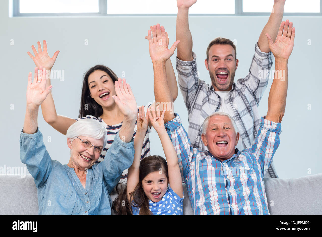 Happy Family cheering dans le salon Banque D'Images