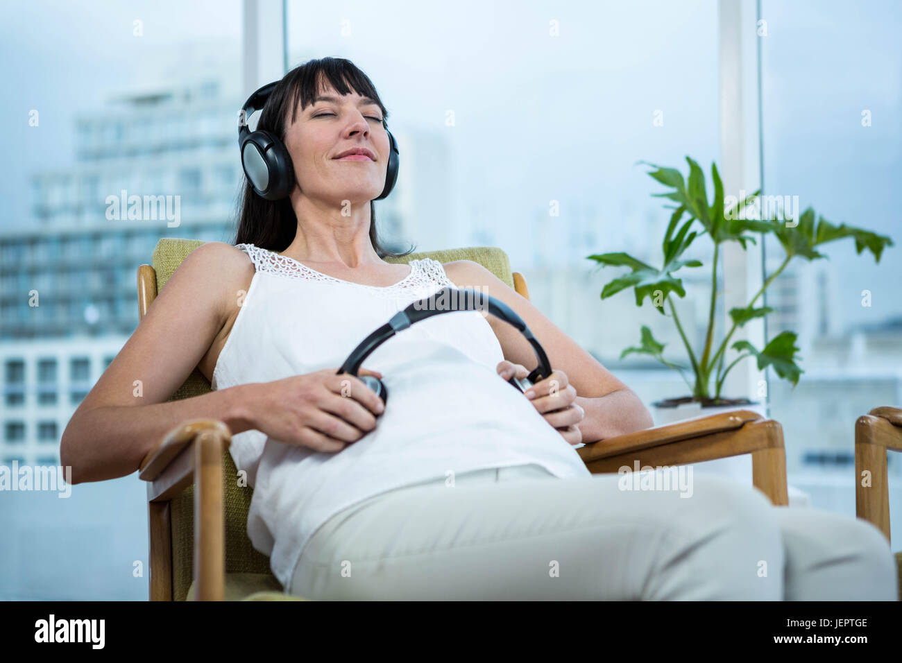 Pregnant woman sitting on chair Banque D'Images