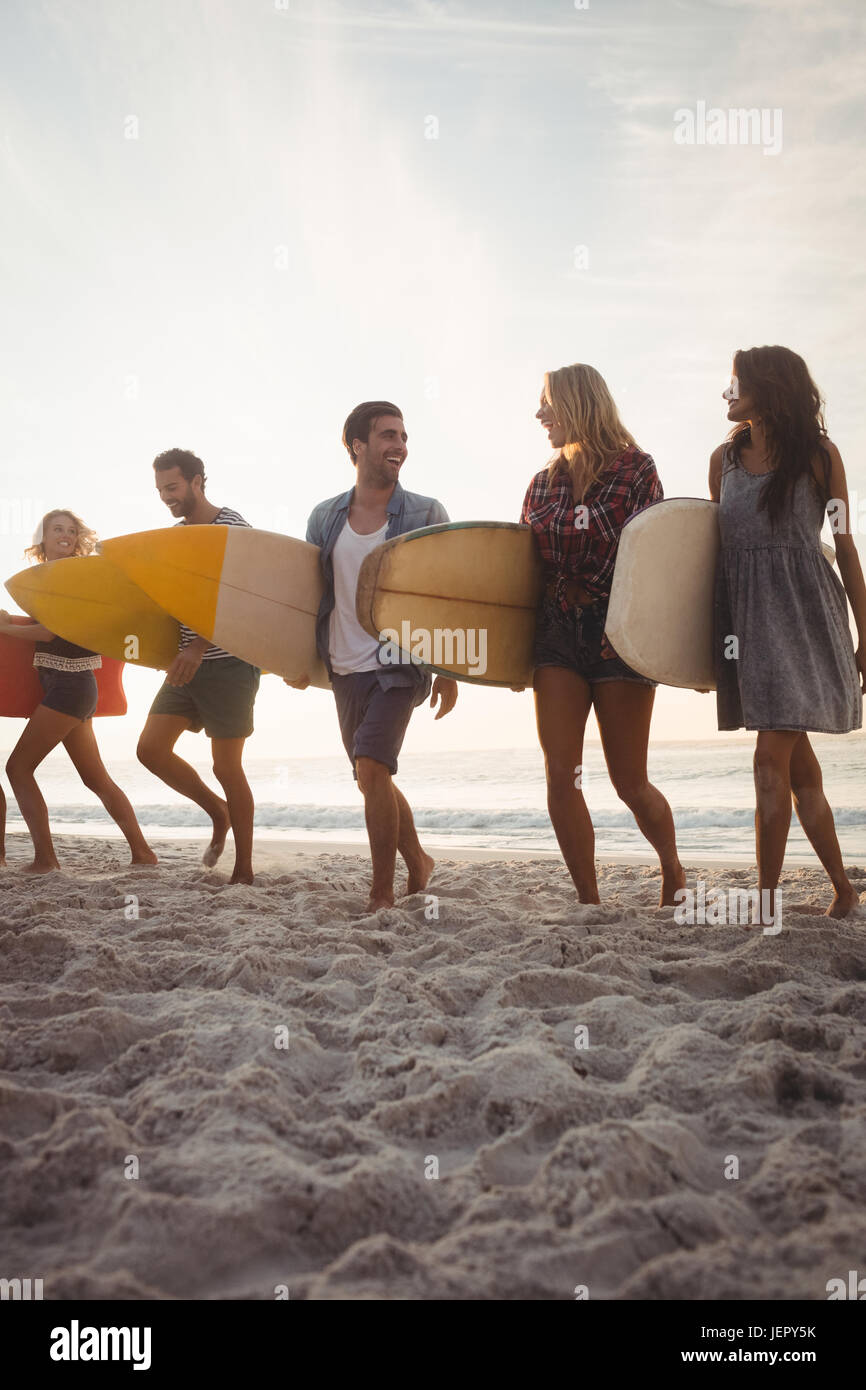 Happy friends walking with surfboards Banque D'Images