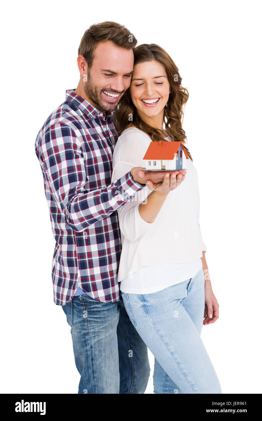 Happy young couple holding model house Banque D'Images