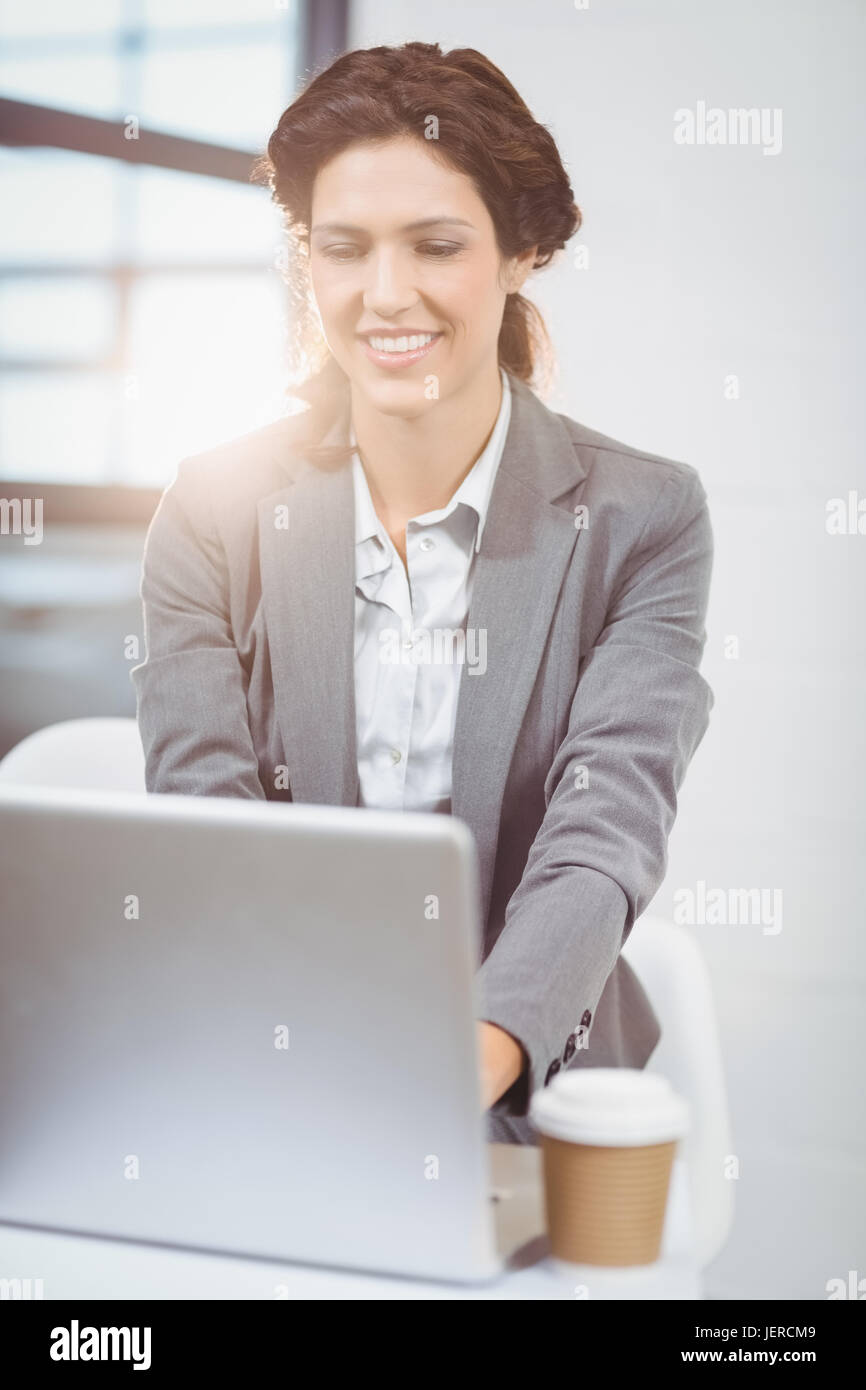Businesswoman using laptop at desk Banque D'Images