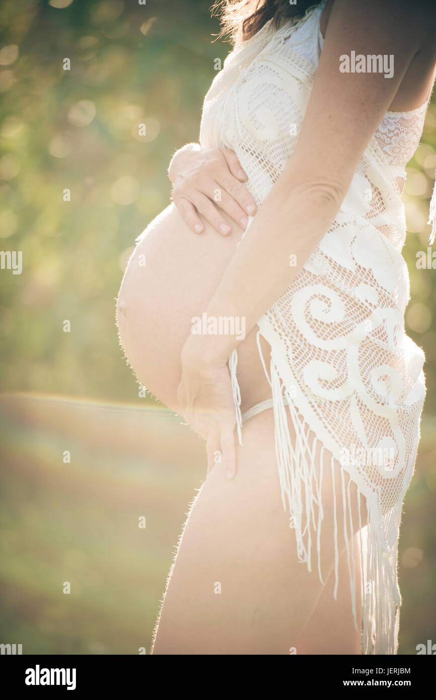 Femme enceinte avec les mains sur le ventre Banque D'Images
