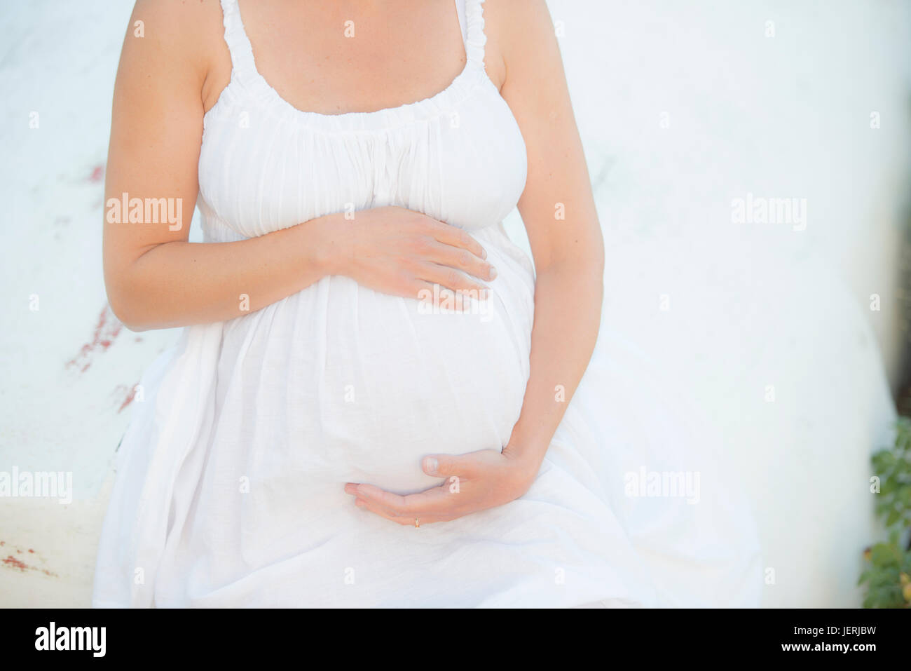 Femme enceinte avec les mains sur le ventre Banque D'Images