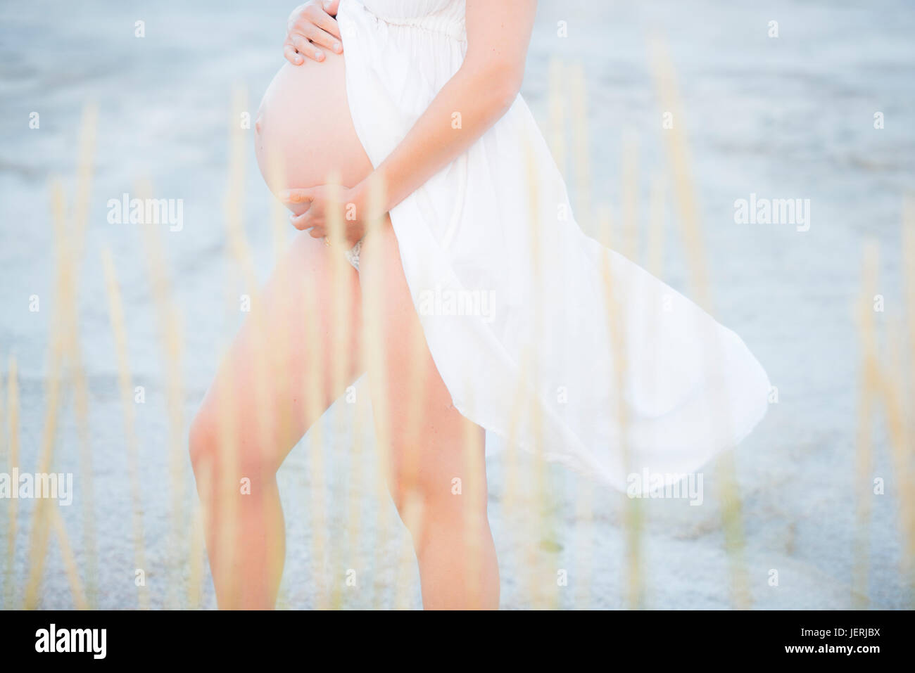 Femme enceinte avec les mains sur le ventre Banque D'Images