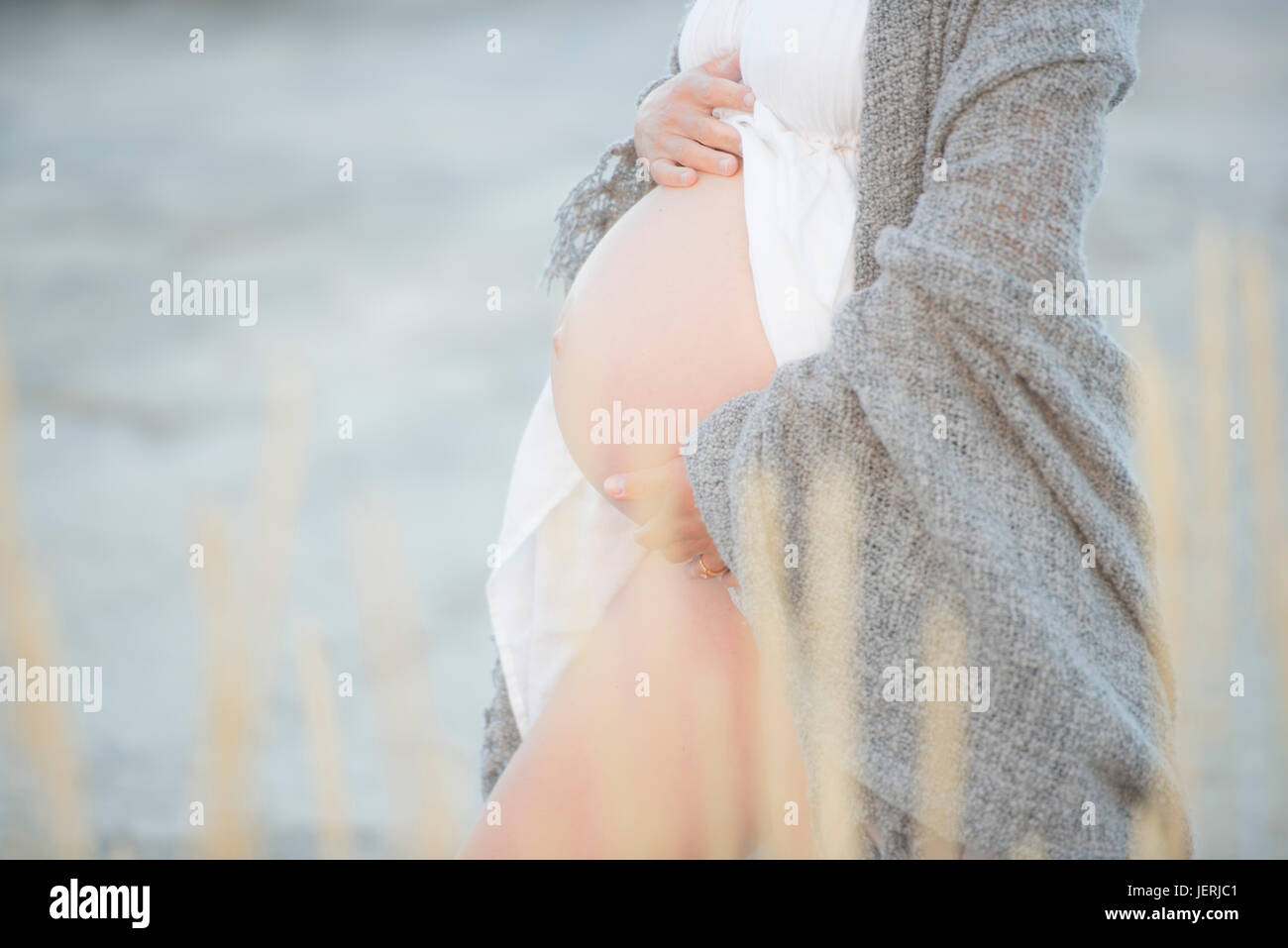Femme enceinte avec les mains sur le ventre Banque D'Images