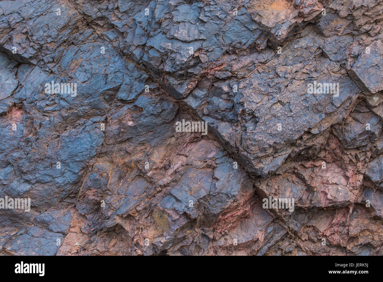 La texture du minerai de fer close up - minéraux naturels dans la mine. La texture de pierre de mine à ciel ouvert. Extraction de minéraux pour l'industrie lourde - la texture de la roche contenant du minerai de fer et de cuivre. Banque D'Images