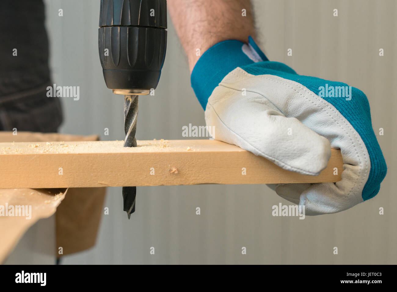 Carpenter handyman en utilisant la perceuse électrique pour faire des trous sur la planche sur la table de l'atelier de menuiserie Banque D'Images