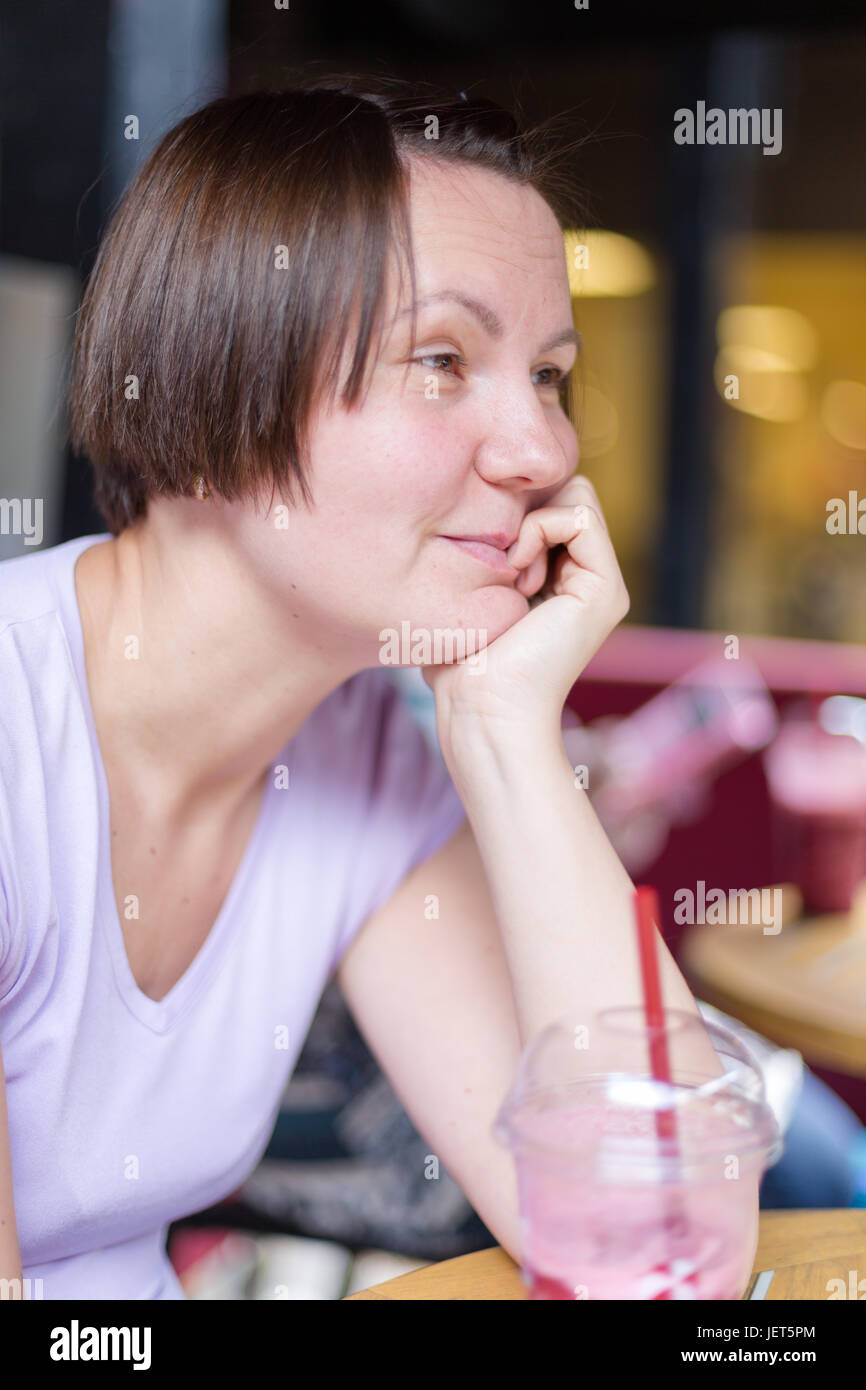 Jeune adulte blanc femme sourire et rire écouter adversaire dans un coffee shop. Close up portrait of Vertical avec une faible profondeur de champ Banque D'Images