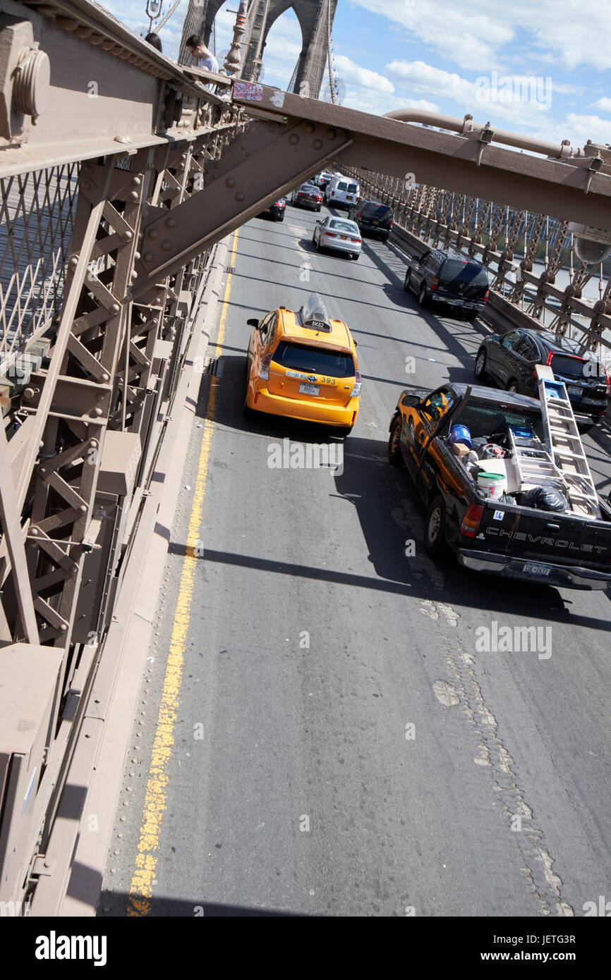 Les véhicules de la circulation de la conduite sur le tarmac usé sur le pont de Brooklyn New York USA Banque D'Images