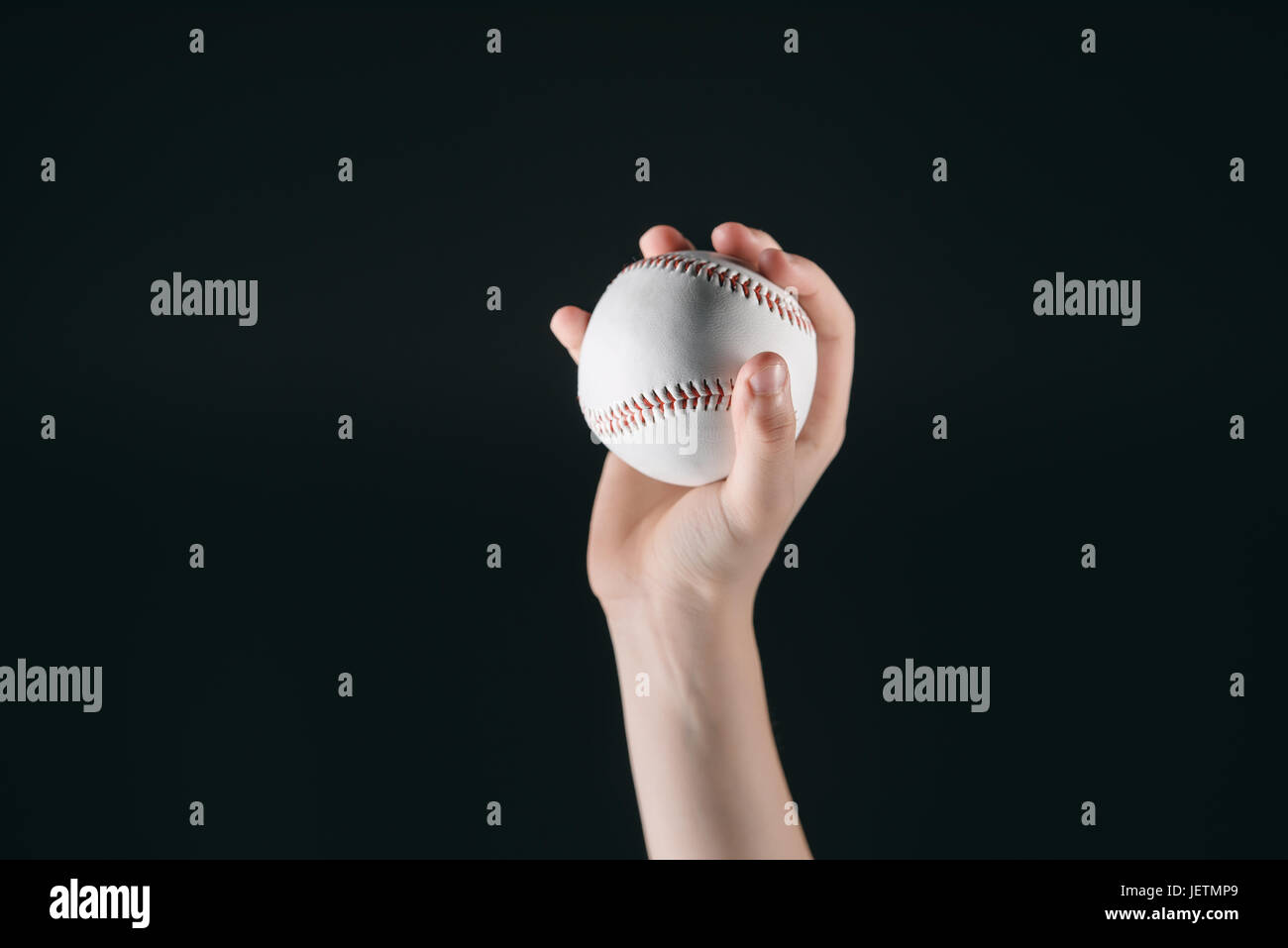 Vue partielle de kid holding baseball ball isolated on black Banque D'Images