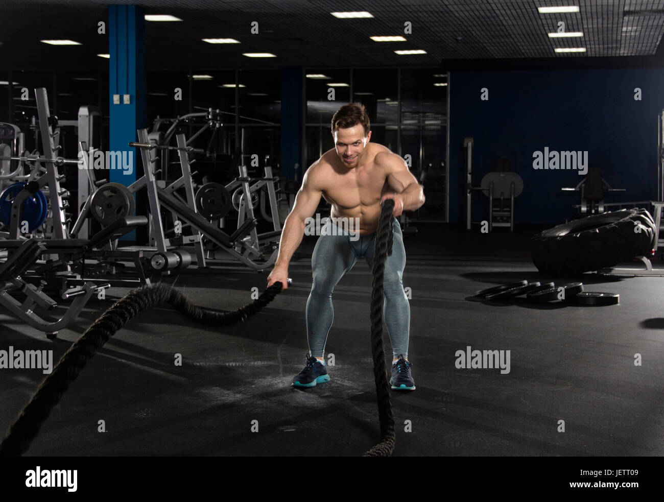 Athlète musclé avec cordes bataille de l'exercice dans un centre de remise en forme moderne.Cross.entraînement entraînement fonctionnel. Banque D'Images