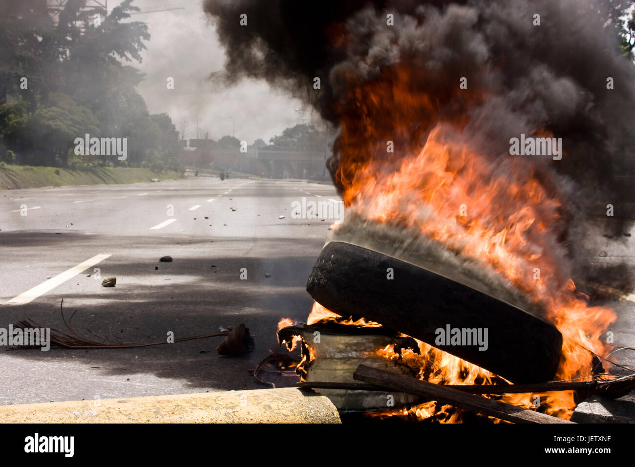 Un pneu sur une route au cours d'une manifestation à Caracas. Banque D'Images