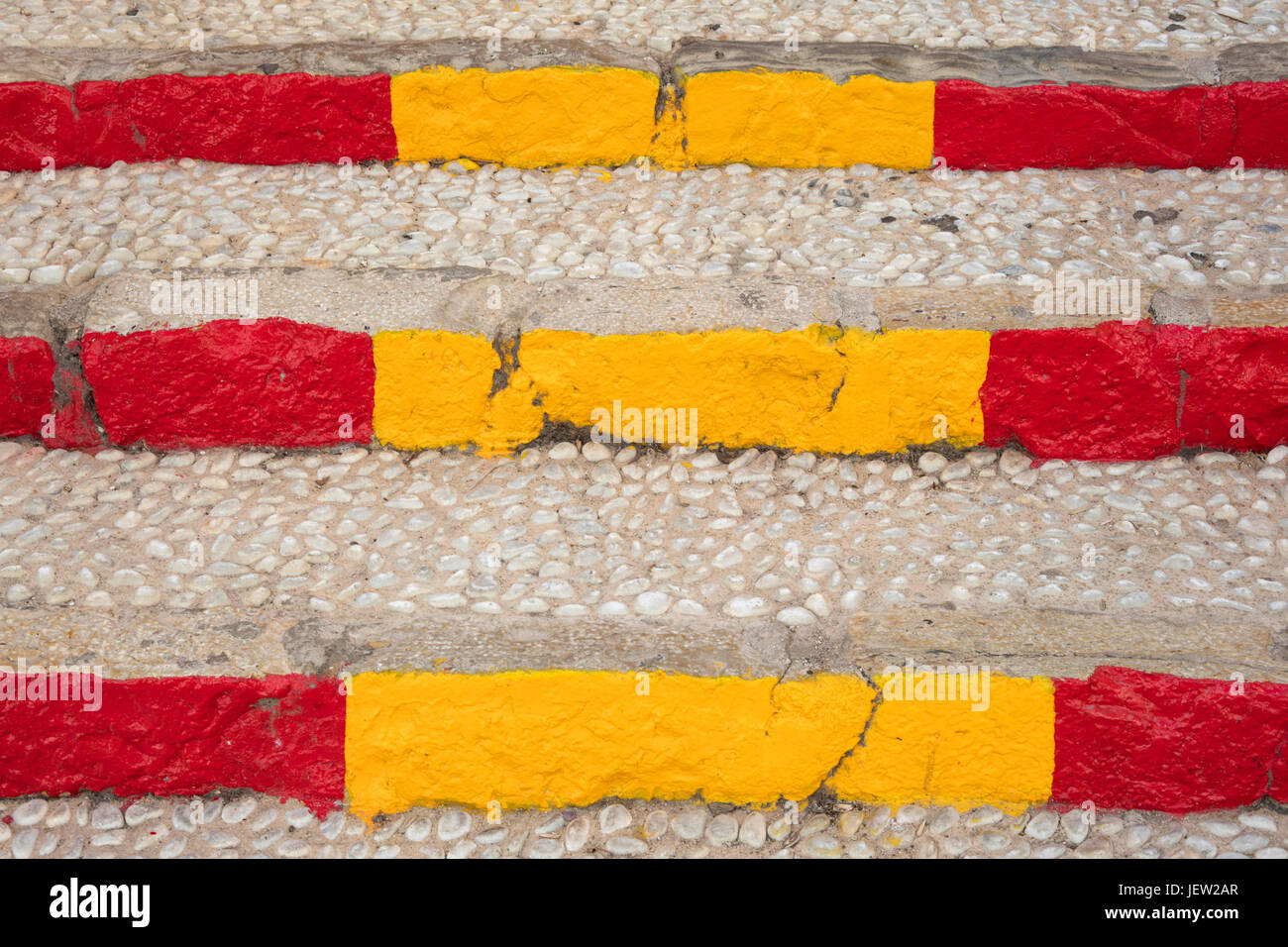 Détail de l'escalier de la rue méditerranéenne faite de pierres et peint aux couleurs du drapeau espagnol Banque D'Images