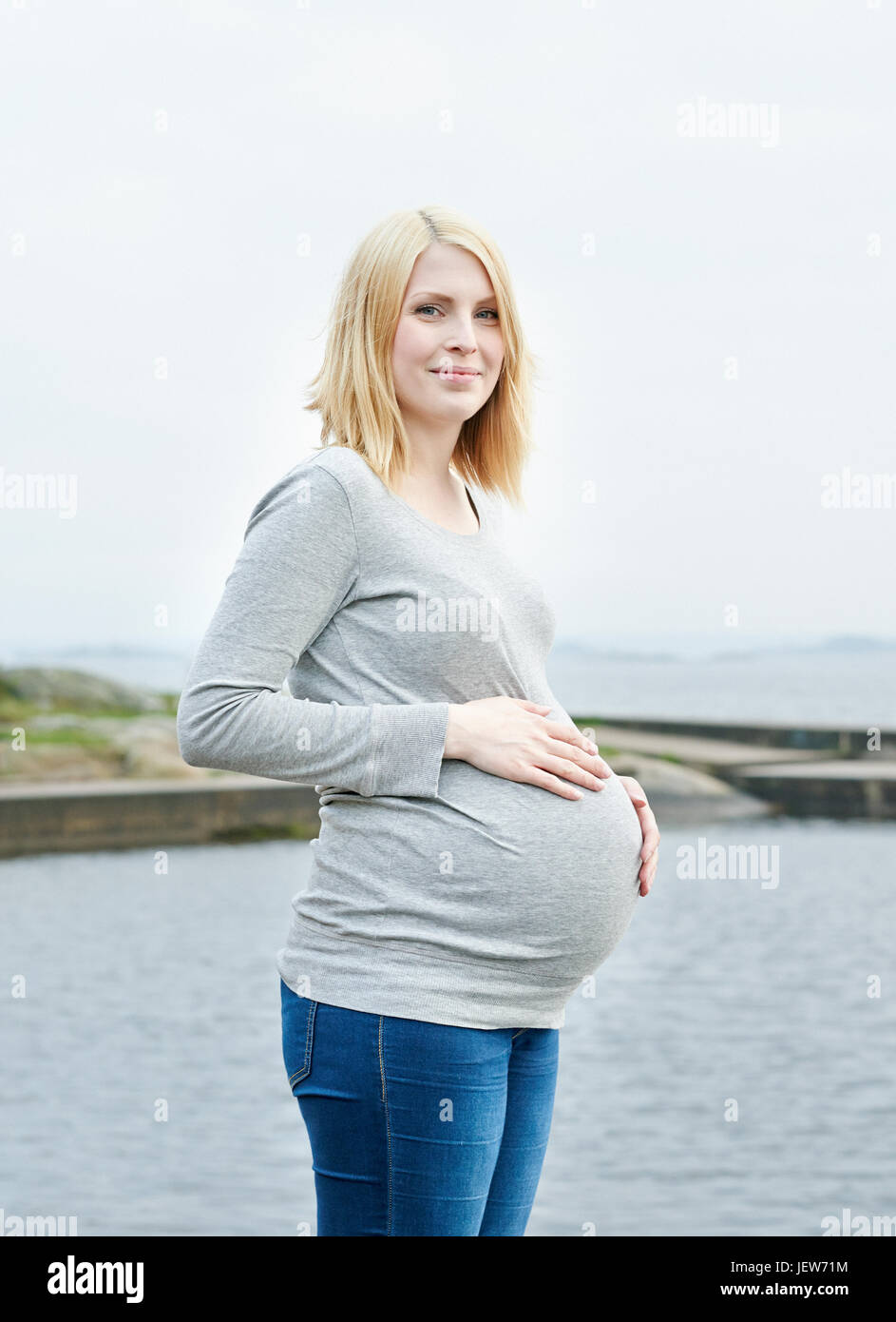 Femme enceinte avec les mains sur le ventre de l'enfer Banque D'Images