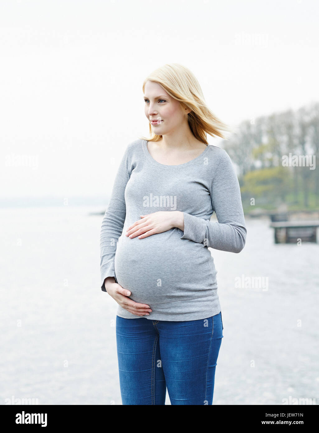 Femme enceinte avec les mains sur le ventre de l'enfer Banque D'Images