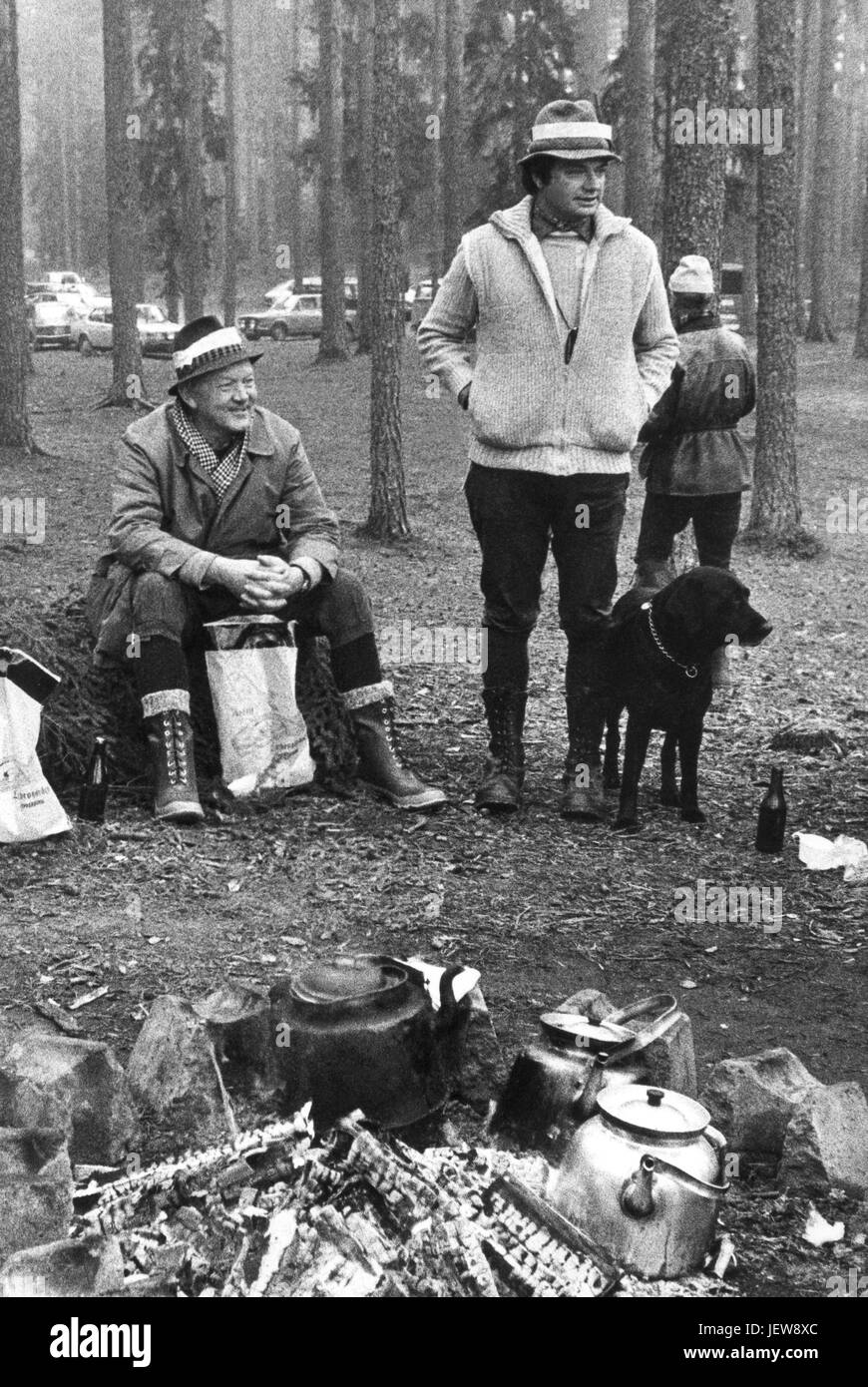 Roi de Suède Carl XIV GUSTAV avec chien autour de l'incendie avec des pots de café à Moose Hunt en 1979 Bergslagen Banque D'Images