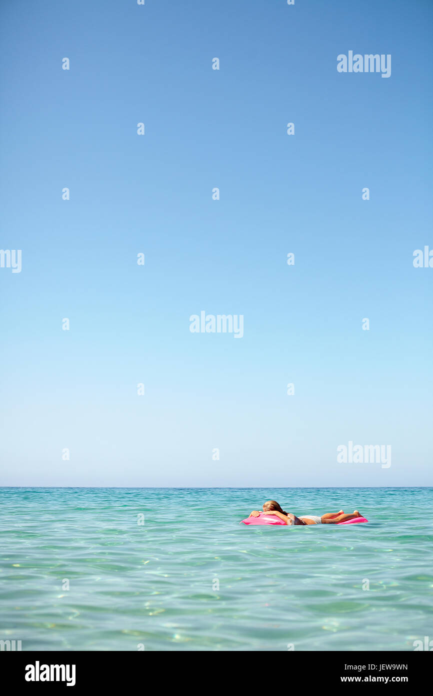 Woman floating in matelas gonflable Banque D'Images