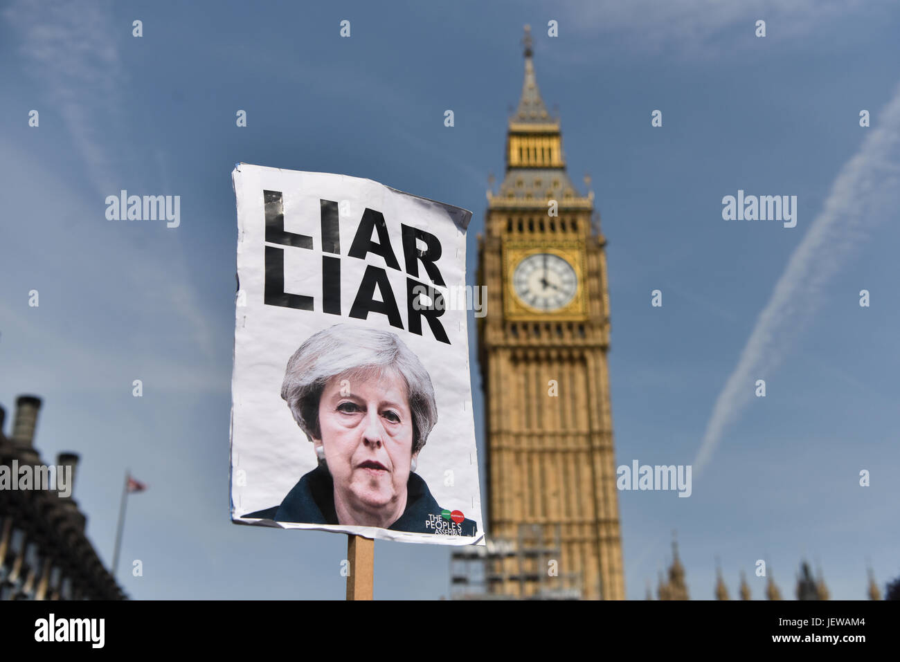 Londres, Royaume-Uni. Jun 21, 2017. Un manifestant est titulaire en place un Theresa peut signer à l'extérieur du Parlement, qui se lit "menteur menteur". La "journée de colère" manifestations furent organisées pour coïncider avec le discours de la reine et l'opposition le nouveau gouvernement conservateur minoritaire, avec un accent particulier sur la récente catastrophe incendie Grenfell. La légende "menteur menteur" fait référence à une chanson sur Theresa May qu'en tête des palmarès au cours de l'élection générale de 2017. Credit : Jacob/Sacks-Jones Alamy Live News. Banque D'Images