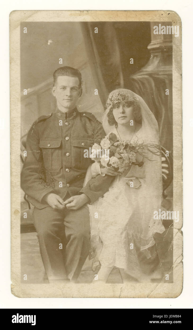 Original WW1 époque fade sepia photo studio portrait de couple de mariage attrayant, mari soldat en uniforme de l'armée, femme portant un beau voile et de la coiffure, portant un bouquet, vers 1918, Angleterre, Royaume-Uni Banque D'Images