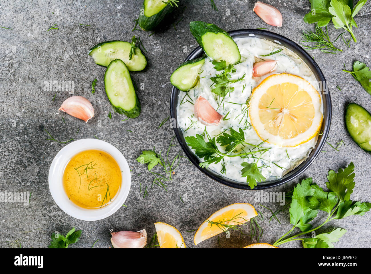 La cuisine grecque traditionnelle et du Caucase. Tzatziki sauce avec des ingrédients - concombre, citron, persil, aneth, l'ail. Sur une table en pierre. Haut de la copie de la vue s Banque D'Images