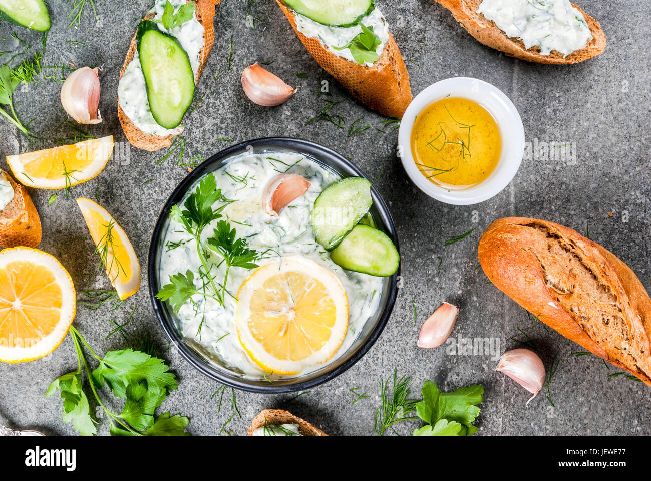 La cuisine grecque traditionnelle et du Caucase. Tzatziki sauce avec des ingrédients - concombre, citron, persil, aneth, l'ail. Sur une table en pierre. Avec des sandwichs Banque D'Images