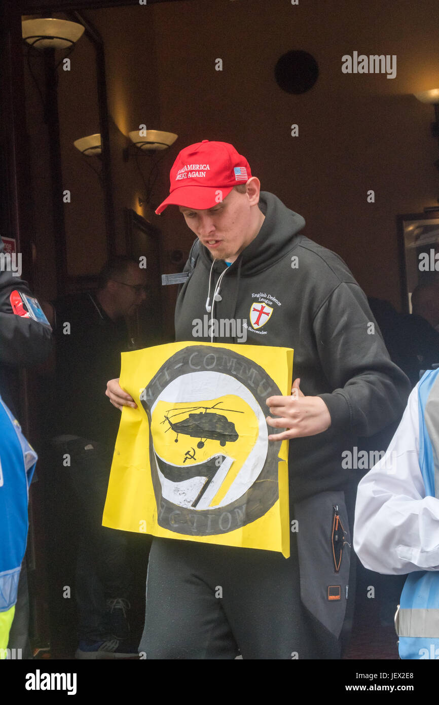 Londres, Royaume-Uni. 24 Juin, 2017. Un homme portant un chapeau et des partisans d'Atout holding a m 'Action' anticommuniste poster sort de la pub Wetherspoons sur Whitehall. Plus tard, escorté de la police autour de 40 manifestants à Charing Cross et le bas du talus de backstreet où ils ont été d'organiser un rassemblement. La police avait déjà déplacé plusieurs centaines d'anti-fascistes contre-manifestants organisés par l'UAF à partir de leur parcours jusqu'à une zone séparée du remblai à proximité où ils ont continué à protester bruyamment contre l'EDL jusqu'à ce que la police les a escortés jusqu'à la gare de Charing Cross. Les deux Banque D'Images