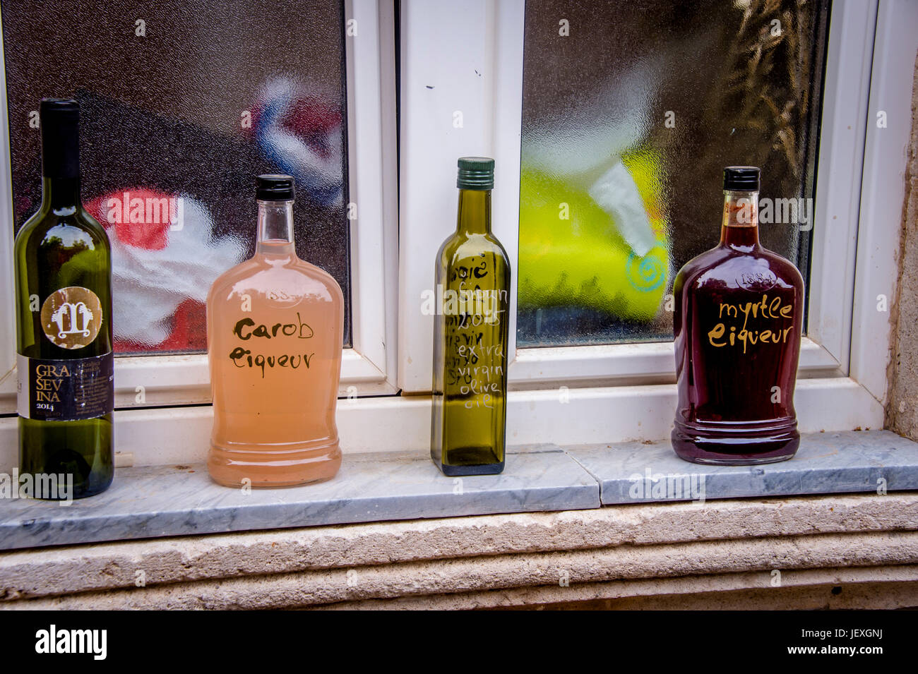 Des bouteilles d'alcool ornent un seuil de fenêtre dans la ville de Sudurad dans la belle île de Šipan, Croatie Banque D'Images