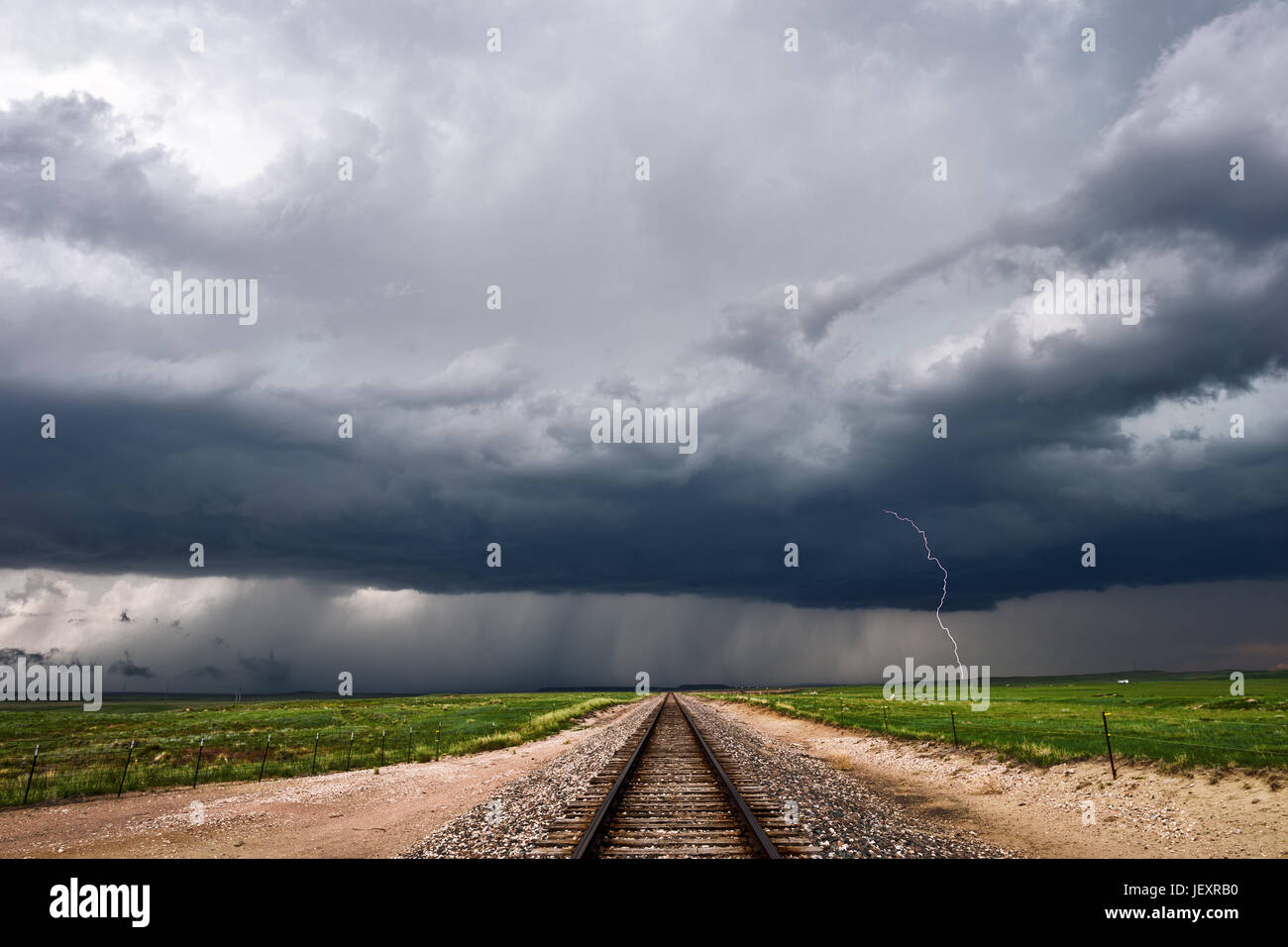 Orage avec foudre et nuages d'orage sombre sur les voies de chemin de fer à Wellington, Colorado Banque D'Images