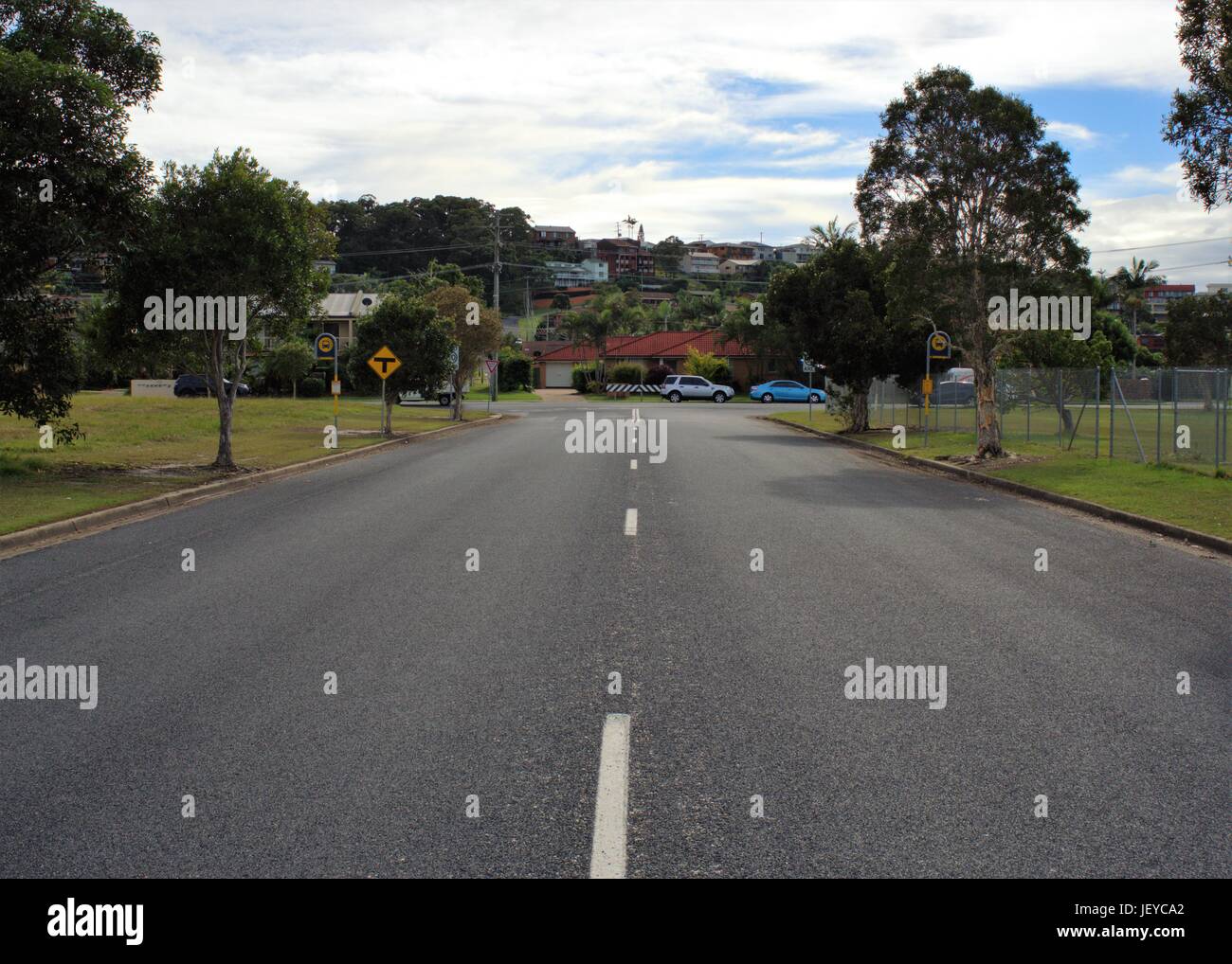 Street à Coffs Harbour, New South Wales. Près de rue déserte en Australie avec la signalisation routière, T point, indicateur de limite de vitesse, les arrêts de bus, des maisons, des voitures. Banque D'Images