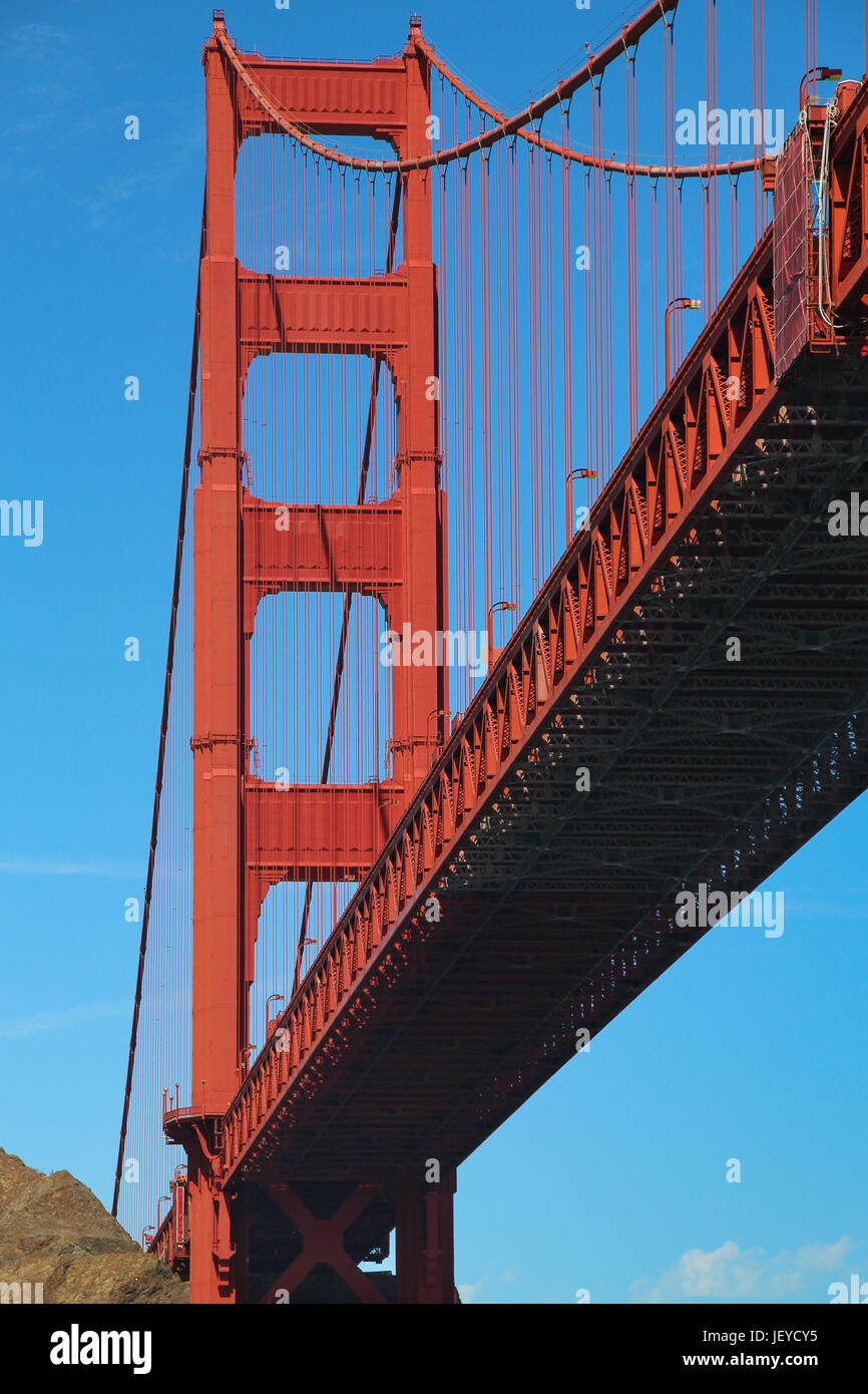 Jusqu'à en-dessous de la travée principale de la San Francisco Golden Gate Bridge, le rouge-orange de la superstructure d'une seule tour contraste avec le bleu du ciel. Banque D'Images