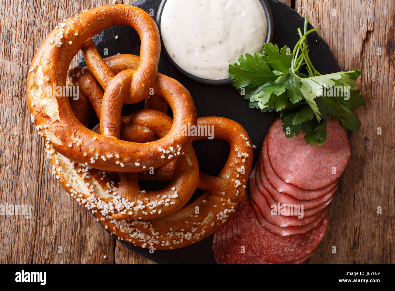 Bretzels salés allemand, de salami et de la sauce sur la table horizontale vue du dessus. Banque D'Images