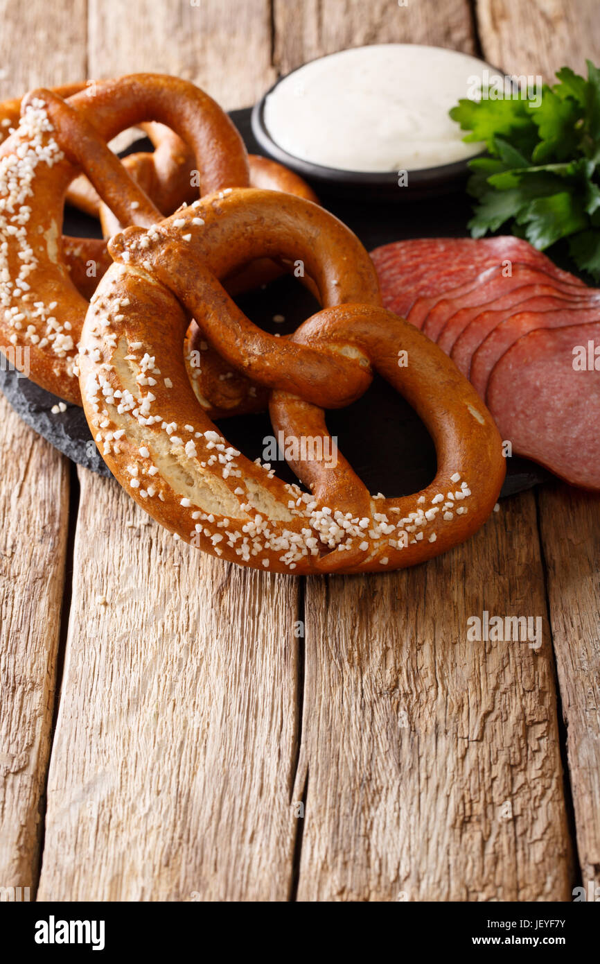 Bretzels allemands traditionnels, des saucisses et à la crème sur la table verticale. Banque D'Images